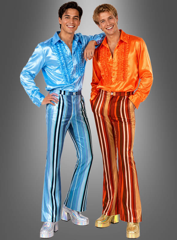 Zwei Männer posieren vor einem schlichten grauen Hintergrund und tragen glänzende, farbenfrohe Outfits im Stil der 1970er Jahre – perfekt für eine Disco-Motto-Party –, darunter Rüschenhemden, Plateauschuhe und gestreifte Schlaghosen für Herren.