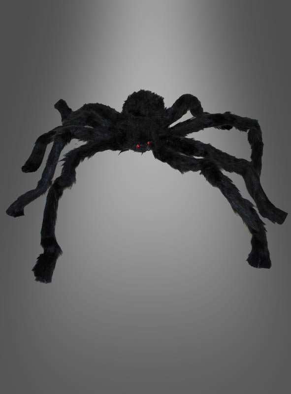 Eine große, schwarze, flauschige Spinne (30–90 cm) als Halloween-Dekoration mit leuchtend roten Augen hebt sich eindrucksvoll von einem schlichten grauen Hintergrund ab – perfekt, um mit Ihren Halloween-Spinnen eine gruselige Atmosphäre zu schaffen.