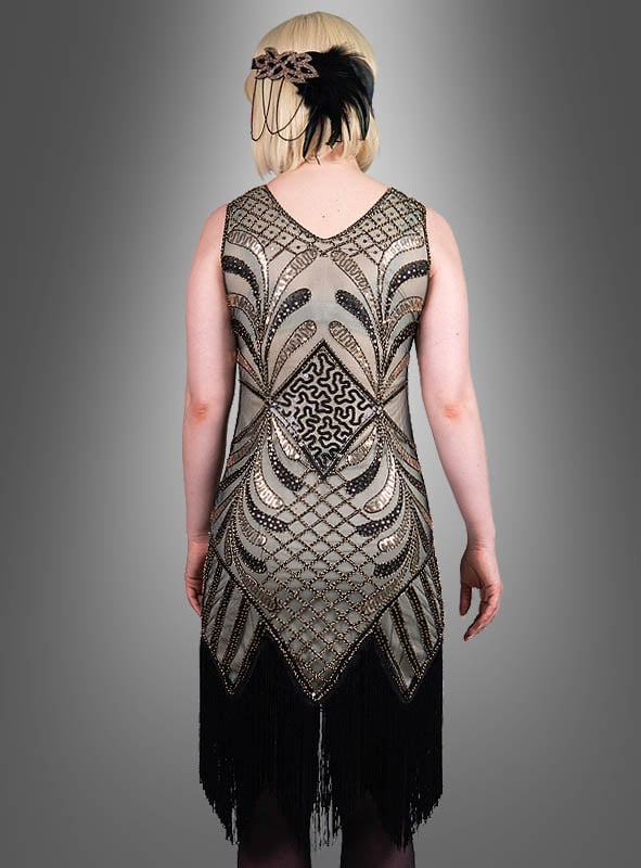 Eine Person, die das „Glamouröses Flapper Kleid Vivian“ trägt – ein mit Perlen besticktes Kleid im Stil der 1920er Jahre mit geometrischem Muster und schwarzen Fransen –, von hinten gesehen und mit einem Feder-Stirnband ergänzt, ist ein atemberaubendes Beispiel für die Mode der 20er Jahre.