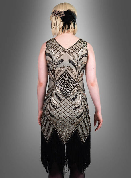 Eine Person, die das „Glamouröses Flapper Kleid Vivian“ trägt – ein mit Perlen besticktes Kleid im Stil der 1920er Jahre mit geometrischem Muster und schwarzen Fransen –, von hinten gesehen und mit einem Feder-Stirnband ergänzt, ist ein atemberaubendes Beispiel für die Mode der 20er Jahre.
