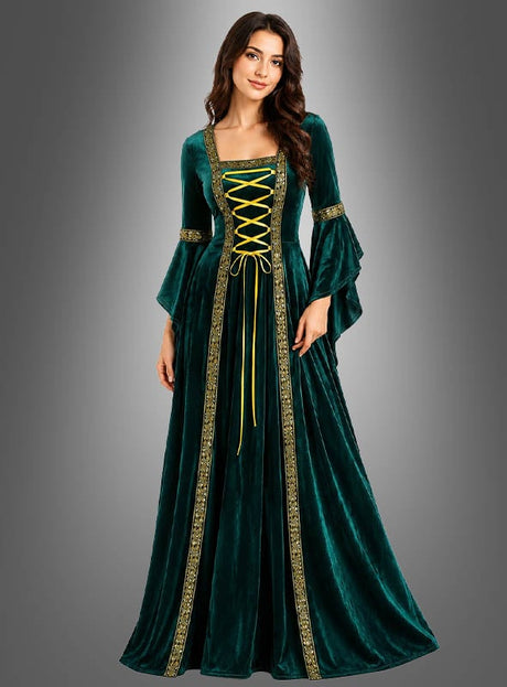 Eine Frau trägt das Mittelalterkleid „Hildegard“ in Grün mit goldenen Verzierungen und einer gelben Schnürung vorne (Kleid mit Schnürung) und steht vor einem schlichten grauen Hintergrund mit Farbverlauf.