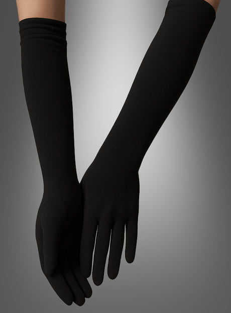 Ein Paar Hände, die die „Lange Handschuhe 40 cm für Damen“ tragen – lange, eng anliegende schwarze Abendhandschuhe –, sind elegant vor einem grau verlaufenden Hintergrund in Szene gesetzt und eignen sich somit perfekt als Abschluss für ein Charleston-Kostüm im Stil der 20er Jahre.