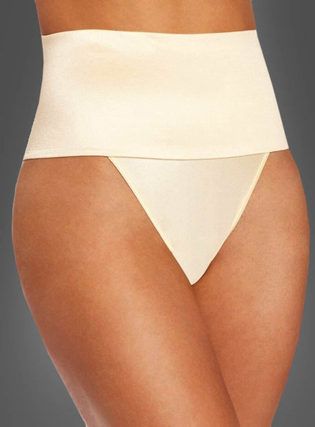 Eine Person trägt den nahtlosen, hautfarbenen Shapewear Bauchweg Mieder-Tanga mit hoher Taille vor einem schlichten dunklen Hintergrund.