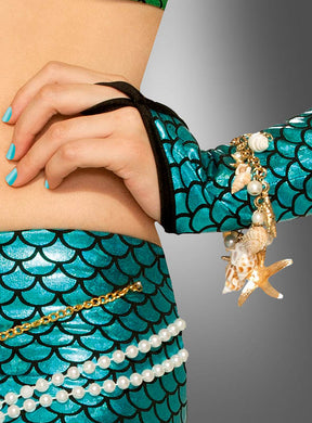 Eine Person in einem glänzenden türkisfarbenen Meerjungfrauenkostüm mit Schuppenmuster, ergänzt durch Accessoires aus Perlen und Muscheln wie das „Armband mit Muscheln Meerjungfrau“ und eine Muschelkette, dazu türkisfarbener Nagellack, vor einem Hintergrund mit Farbverlauf.