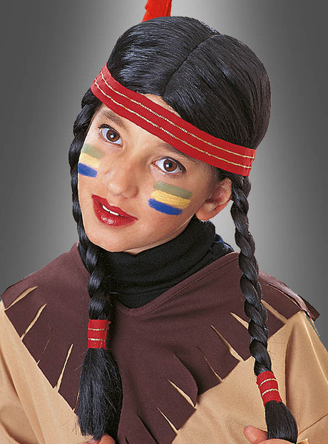 Ein Kind, das die „Indianer-Perücke für Kinder“ trägt, mit im Indianerstil geflochtenen Haaren, bunten Streifen aus Gesichtsbemalung und einem Stirnband, blickt vor einem grauen Hintergrund in die Kamera.