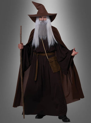 Im „Magischer Zauberer“-Kostüm Deluxe – mit langem grauen Bart, brauner Robe, spitzem Hut und Holzstab – ist dieser Look ideal für jede Fantasy-Veranstaltung vor einem edlen grauen Hintergrund.