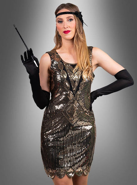 Eine Frau, die das „Premium Paillettenkleider Ruby“ trägt – ein Paillettenkleid im Stil der 1920er Jahre –, dazu lange schwarze Handschuhe und eine Zigarettenspitze in der Hand, steht vor einem grauen Hintergrund mit Farbverlauf.