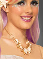 Eine Frau mit hellviolettem Haar trägt eine goldene Halskette „Muscheln Meerjungfrau“, die mit Muschel- und Perlenanhängern verziert ist. Dazu passen ihr schimmerndes Make-up und dekorative Gesichtssteine – ein Look, der perfekt zu jedem Meerjungfrau-Kostüm passt.