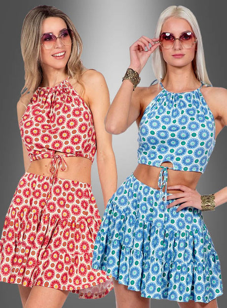 Zwei Frauen, die passende Sommer-Outfits aus Rock und Oberteil im Boho-Stil tragen – die eine in Rot und Gelb, die andere in Blau und Grün –, posieren vor einem grauen Hintergrund mit Farbverlauf. Ihr aufeinander abgestimmter Look besticht durch kokette Miniröcke und einen verspielten Boho-Stil, wodurch sich diese Outfits perfekt für lebhafte Sommertage eignen.