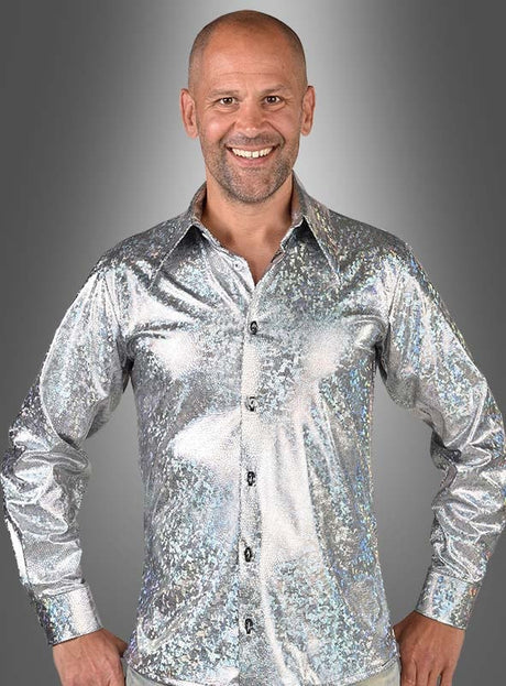 Eine lächelnde Person trägt das „Deluxe 70er Disco Hemd Hologramm“, ein langärmeliges Hemd mit Knöpfen und glänzenden silbernen Pailletten, und steht vor einem grauen Hintergrund mit Farbverlauf – perfekt für jede 70er-Jahre-Disco-Party.