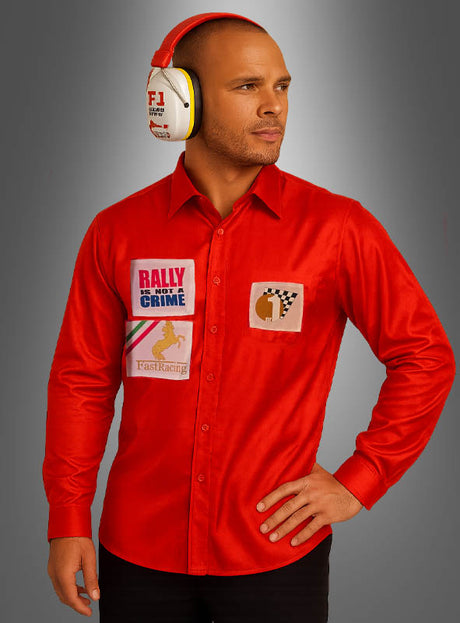 Ein Mann, der das „Formel-1-Rennfahrer“-Shirt zum Sonderpreis trägt, das mit Rennsport-Aufnähern verziert ist, und weiße Kopfhörer trägt, steht vor einem grauen Hintergrund mit Farbverlauf.
