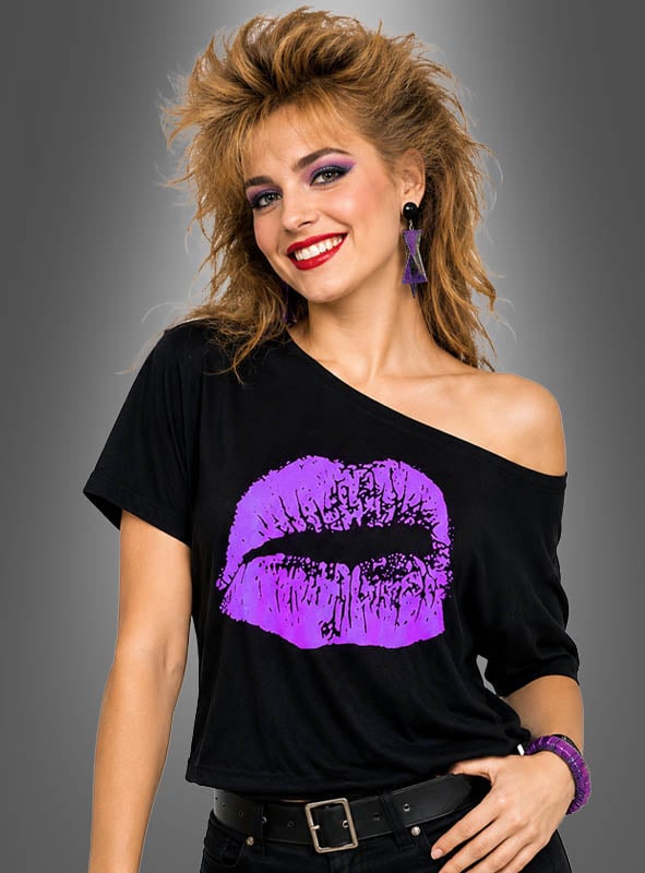 Eine lächelnde Person mit toupierten Haaren und violetten Ohrringen trägt das 80er-Jahre-Shirt „Kiss“ – ein übergroßes Top mit freien Schultern, das mit einem großen, neonvioletten Lippenmotiv verziert ist, das vom „Neon Kiss“-Trend inspiriert ist – und steht vor einem grauen Hintergrund, wodurch der kühne Geist der 80er-Jahre-Mode perfekt eingefangen wird.