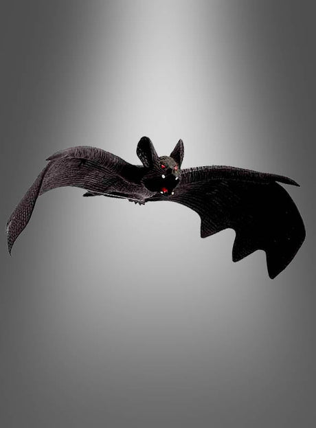 Eine schwarze Fledermaus mit ausgebreiteten Flügeln und roten Augen fliegt vor einem grauen Hintergrund mit Farbverlauf – eine ideale Wahl aus der Kollektion „Deko Fledermaus – verschiedene Versionen“ für Ihre Halloween-Dekoration oder als auffällige Fledermaus-Hängedekoration.