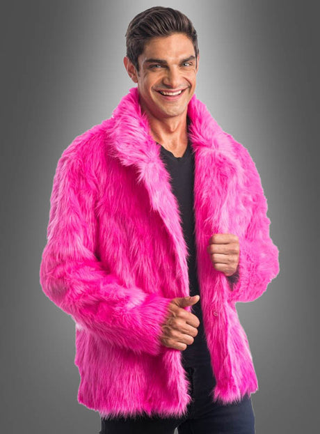 Ein Mann steht vor einem grauen Hintergrund, lächelt und trägt die „Coole Langhaar Plüschjacke Herren“ in leuchtendem Pink über einem schwarzen Hemd – eine auffällige Karnevalsjacke, die seinem Look eine verspielte Note verleiht.