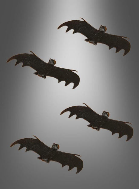 Vier schwarze Fledermäuse aus unserer Kollektion „Deko-Fledermaus – verschiedene Versionen“ fliegen vor einem grauen Hintergrund mit Farbverlauf, die Flügel weit ausgebreitet und in einzigartigen Winkeln angeordnet – perfekt als Halloween-Dekoration oder als auffällige Deko-Fledermaus für Ihre festliche Dekoration.