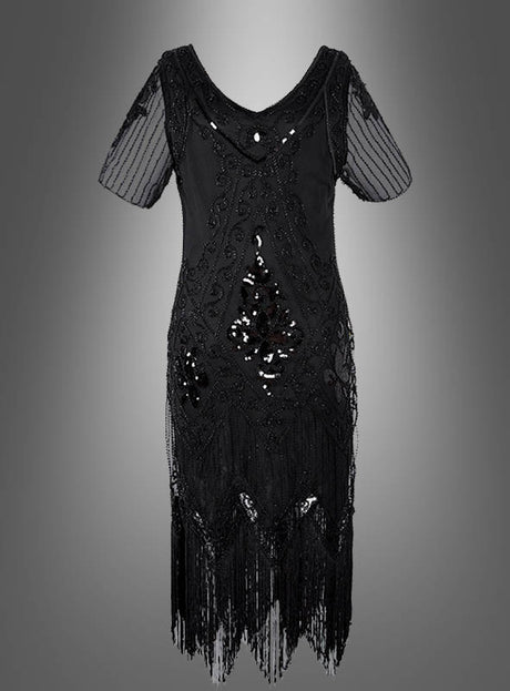 Das 20er Paillettenkleid mit transparenten Ärmeln „Gitta“ ist ein schwarzes, knielanges Kleid mit transparenten kurzen Ärmeln, eleganten Perlenverzierungen, funkelnden Pailletten-Details, die an ein klassisches Paillettenkleid für Damen erinnern, sowie verspielten Fransen am Saum, präsentiert vor einem grauen Hintergrund mit Farbverlauf.