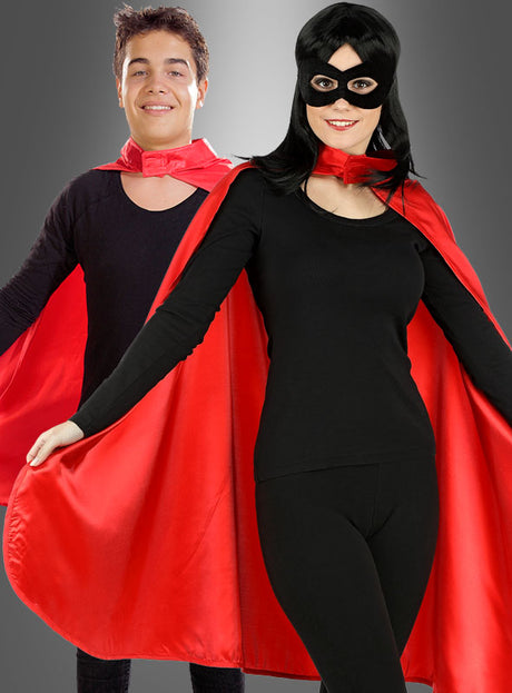 Zwei als Superhelden verkleidete Personen tragen elegante schwarze Kostüme, die jeweils mit dem „Roten Umhang für Erwachsene Superhelden“ – einem auffälligen roten Umhang – versehen sind. Eine der beiden rundet ihren Look mit einer geheimnisvollen schwarzen Maske ab. Sie stehen selbstbewusst vor einem grauen Hintergrund mit Farbverlauf.