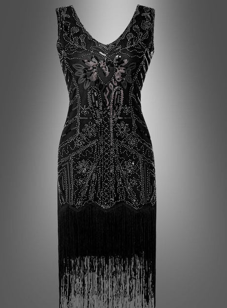 Das „Deluxe 20er Paillettenkleid May“ ist ein ärmelloses schwarzes Kleid, das mit aufwendigen Perlenstickereien und Blumenmustern verziert ist und von der Mode der 20er Jahre inspiriert ist. Es verfügt über einen V-Ausschnitt und einen Fransenbesatz am Saum, der an klassische Charleston-Kleider erinnert, und wird elegant vor einem grau verlaufenden Hintergrund präsentiert.