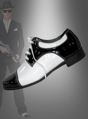 Im Mittelpunkt stehen die „Mafia Gangster“-Schuhe, im Hintergrund ist schemenhaft ein Mann in einem Nadelstreifenanzug und mit Fedora zu erkennen, der eine Maschinenpistole in der Hand hält – eine auffällige Anspielung auf ein Al-Capone-Kostüm. Diese klassischen Schuhe runden das typische Outfit der 20er Jahre ab und erinnern an die Eleganz und Faszination der „Roaring Twenties“.