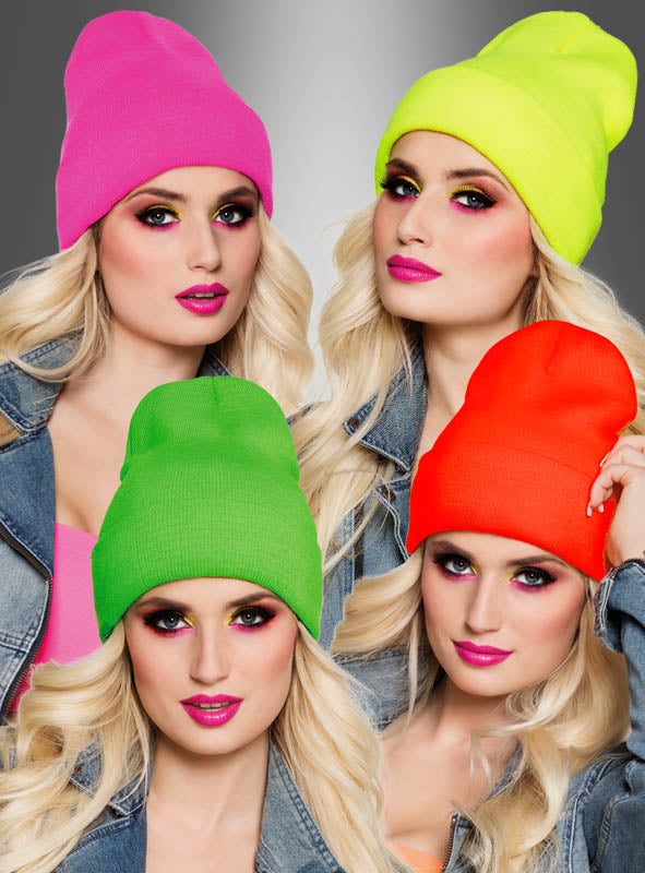 Vier Frauen mit langen blonden Haaren tragen die Strickmütze „Beanie“ in coolen Neonfarben – Pink, Gelb, Grün und Orange – kombiniert mit Jeansjacken vor einem grauen Hintergrund mit Farbverlauf.
