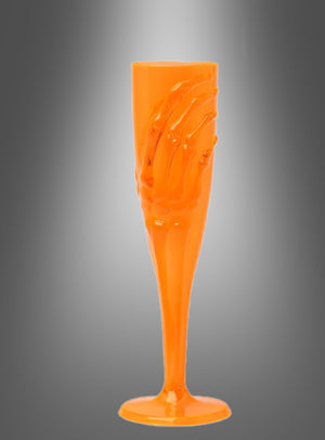 Das „Skeletthand Sektglas 20 cm“, ein orangefarbenes Sektglas aus Kunststoff mit einem Skeletthand-Motiv, wird vor einem schattierten grauen Hintergrund präsentiert – perfekt als Halloween-Tischdeko für Ihre nächste Gothic-Party oder gruselige Feier.