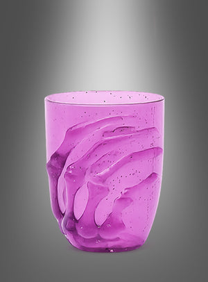 Ein durchscheinendes, violettes „Halloween-Glas 10 cm mit Skelett-Hand“ ist an der Seite mit einem erhabenen Skelett-Hand-Motiv verziert, das sich um die Seite windet, und eignet sich somit ideal als gruseliges Halloween-Glas für die Tischdekoration, präsentiert vor einem grau abgestuften Hintergrund.