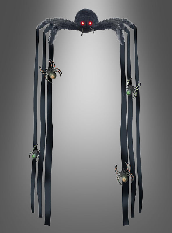 Eine riesige Deko-Spinne (90 cm), mit roten Augen und langen, bandartigen Beinen, verziert mit kleineren Spinnen, hängt vor einem schlichten grauen Hintergrund – perfekt, um Ihrer Halloween-Dekoration einen gruseligen Touch zu verleihen.