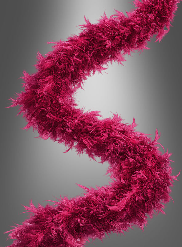 Das Federboa „20er Jahre“ (180 cm) in leuchtendem Magenta ist in einer eleganten S-Form vor einem dezenten grauen Farbverlauf angeordnet.