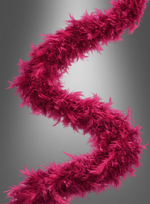 Das Federboa „20er Jahre“ (180 cm) in leuchtendem Magenta ist in einer eleganten S-Form vor einem dezenten grauen Farbverlauf angeordnet.