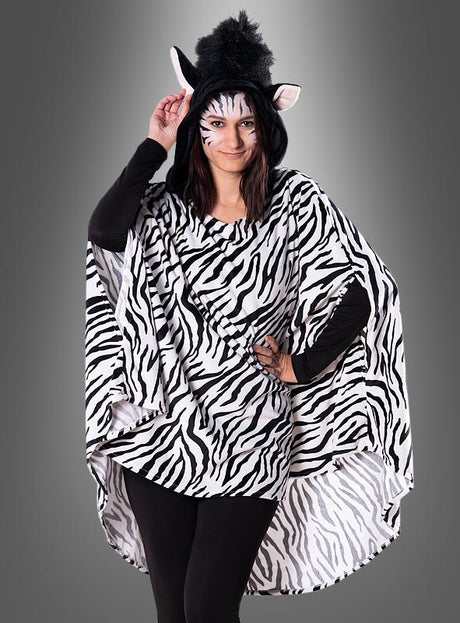 Eine Person, die den Plüsch-Zebra-Poncho in den Größen XS bis XXXL trägt – mit schwarz-weißen Streifen, Zebra-Ohren, Gesichtsbemalung und schwarzen Leggings –, steht vor einem grauen Hintergrund und bildet so ein auffälliges Karnevalskostüm oder einen verspielten Tierponcho.