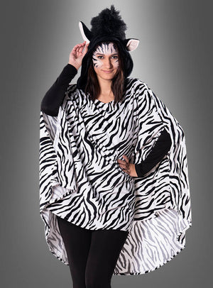 Eine Person, gekleidet in einen verspielten Plüsch-Zebra-Poncho in den Größen XS bis XXXL, kombiniert mit einer schwarzen Hose, Zebra-Gesichtsbemalung und einem Hut mit Zebra-Ohren und -Mähne, posiert vor einem grauen Hintergrund – damit ist dies ein ideales Karnevalskostüm oder ein von Tieren inspirierter Tierponcho für festliche Anlässe.