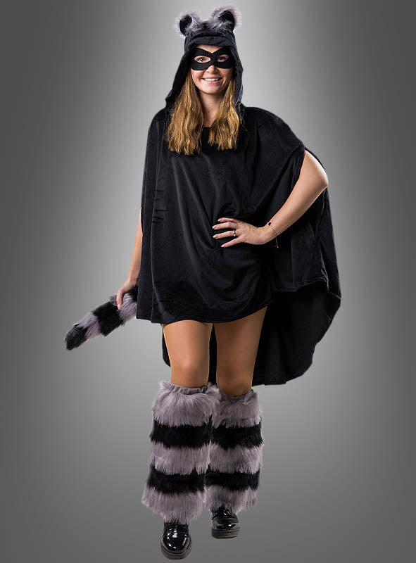 Eine lächelnde Frau posiert in einem Waschbärenkostüm, bestehend aus dem wandelbaren schwarzen Plüschponcho (XS–XXXL) mit Kapuze und Ohren, einer Maske, einem gestreiften Schwanz und pelzigen Stulpen – perfekt für die Karnevalsfeierlichkeiten.