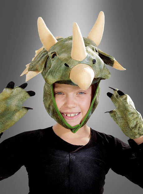 Ein Kind, das das Triceratops-Kostümset trägt – bestehend aus einem grünen Kostüm mit einem Kopfschmuck mit drei Hörnern und passenden Handschuhen –, posiert vor einem grauen Hintergrund.