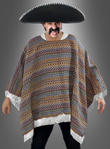 Eine Person, die einen großen schwarzen Sombrero, einen bunten „Mexikaner Poncho Deluxe“ in den Größen S bis XXXL mit Ethno-Muster sowie einen falschen Schnurrbart trägt, steht mit leicht ausgestreckten Armen vor einem grauen Hintergrund.
