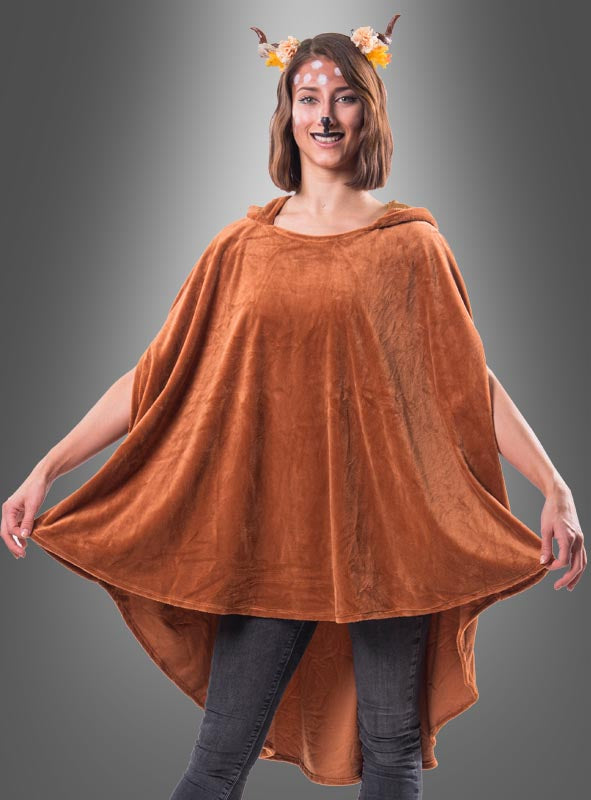 Eine Person trägt den wandelbaren braunen Poncho aus Plüsch in den Größen XS bis XXXL, dazu ein Stirnband mit Hirschgeweih, schwarze Nasenmalerei und weiße Gesichtsbemalung, und steht vor einem grauen Hintergrund. Dieser kuschelige Tierponcho für Erwachsene verleiht dem verspielten Kostüm einen zusätzlichen Hauch von Verspieltheit.