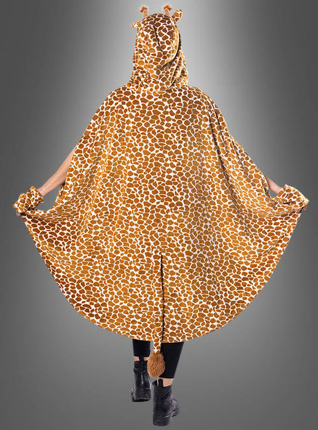 Eine Person, die den „Plüsch-Giraffen-Poncho mit Haarreif S–XXXL“ trägt – ein kuscheliger Umhang mit Giraffenmuster und Kapuze, komplett mit Ohren und Hörnern sowie einem Schwanz am Rücken – ideal als Tierponcho für jede Safari-Mottoparty oder als niedliches Giraffenkostüm.
