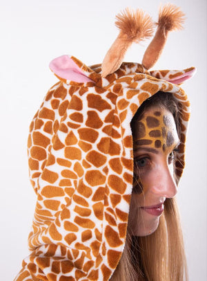 Person in einem Plüsch-Giraffen-Poncho mit passendem Haarreif (Plüsch-Giraffenponcho mit Haarreif S–XXXL), mit weichen Giraffenohren und -hörnern sowie auf das Muster abgestimmter Gesichtsbemalung, im Seitenprofil vor einem einfarbigen Hintergrund – ideal für eine Safari-Mottoparty oder als Teil eines gemütlichen Tierponcho-Kostüm-Ensembles.