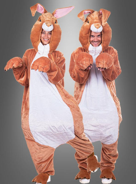 Zwei Personen, die identische Deluxe-Osterhasen-Kostüme aus waschbarem Plüsch trugen, standen nebeneinander, lächelten und posierten mit nach oben gestreckten Händen, die wie Pfoten aussahen, vor einem schlichten Hintergrund mit Farbverlauf. Ihr verspielter Look ist perfekt für alle, die ein lustiges Unisex-Kostüm für Gruppenveranstaltungen suchen.