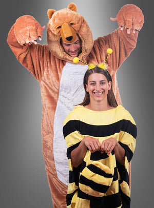 Eine Person, die das Deluxe-Bär-Kostüm aus waschbarem Plüsch trägt, steht hinter einer anderen Person in einem Bienenkostüm; beide posieren spielerisch vor einem grauen Hintergrund.