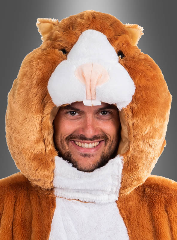 Vor einem grauen Hintergrund mit Farbverlauf steht ein Mann, der das „Plüsch Hamsterkopf-Maskenset waschbar“ trägt – ein Set mit einem braun-weißen Plüsch-Hamster-Motiv mit fröhlichem Gesichtsausdruck und einer detailreichen, waschbaren Hamsterkopfmaske.