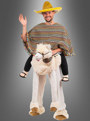 Ein Mann, der das zweiteilige „Lama-Kostüm – Alpaka-Reitkostüm“ trägt, komplett mit Sombrero und Poncho, scheint auf einem Plüsch-Alpaka mit lustigen künstlichen Beinen zu reiten, winkt und lächelt vor einem grauen Hintergrund – und schafft so eine verspielte und lebhafte Szene.