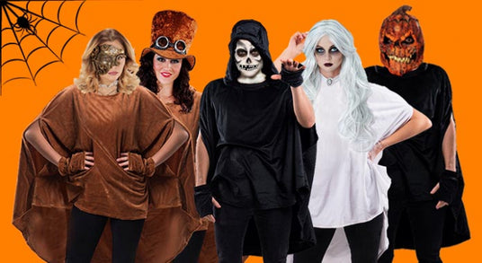 Fünf Personen in Halloween-Kostümen stehen vor einem orangefarbenen Hintergrund, in dessen Ecke ein Spinnennetz zu sehen ist. Zu ihren Kostümen gehören ein Kürbiskopf, weiße Haare, Skelett-Make-up und Masken.