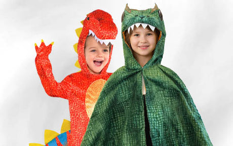 Zwei Kinder in Dinosaurierkostümen: eines in einem roten Kostüm mit gelben Stacheln und das andere in einem grünen Kostüm mit einer Kapuze, an der Zähne angebracht sind.