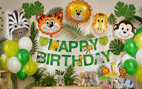Geburtstagsdekoration im Dschungel-Stil mit Tierballons, grünen und weißen Ballons, Plüschtieren und einem „Happy Birthday“-Banner.