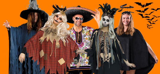 Fünf Personen tragen verschiedene Halloween-Kostüme, darunter eine Hexe, eine Vogelscheuche, ein Skelett und zwei weitere Figuren, und stehen vor einem orangefarbenen Hintergrund, auf dem Fledermäuse herumfliegen.