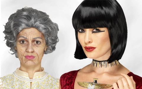 Zwei Personen posieren; eine trägt ein Kostüm als alte Frau mit grauer Perücke und Make-up, die andere hat eine schwarze Bob-Perücke, auffälliges Make-up, eine Halskette und ein rotes Kleid.