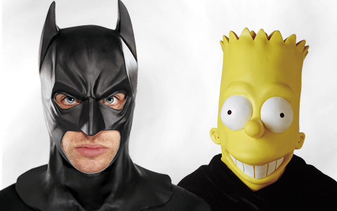 Zwei Personen posieren nebeneinander; eine trägt eine Batman-Maske, die andere eine große Bart-Simpson-Maske. Beide blicken vor einem schlichten weißen Hintergrund direkt in die Kamera.