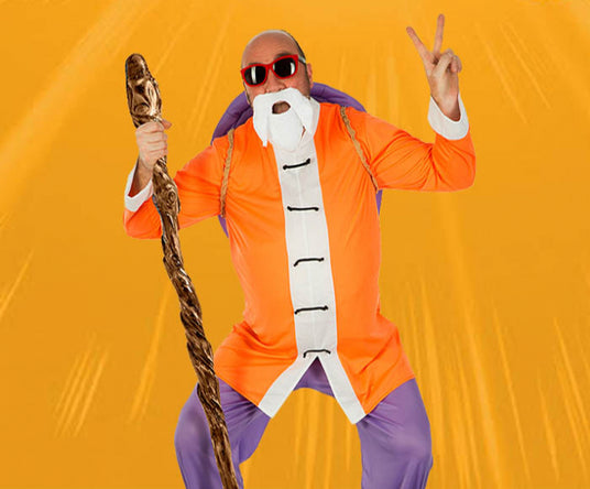 Eine Person in einem orangefarbenen Gewand, mit weißem Bart und Sonnenbrille, die einen Holzstab in der Hand hält, macht vor einem orangefarbenen Hintergrund das Friedenszeichen.