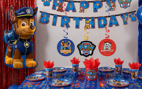 Geburtstagsfeier im PAW Patrol-Stil mit Figuren-Dekorationen, Bannern, Geschirr und einem großen Chase-Ballon in Blau und Rot.