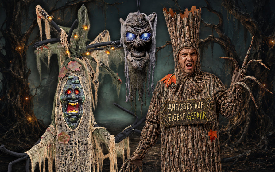 Zwei Personen in aufwendigen Halloween-Kostümen: eine als Spukbaum mit Warnschild und eine als gruselige Kreatur mit leuchtendem Gesicht und Spinnenbeinen, in einer dunklen, unheimlichen Waldkulisse.